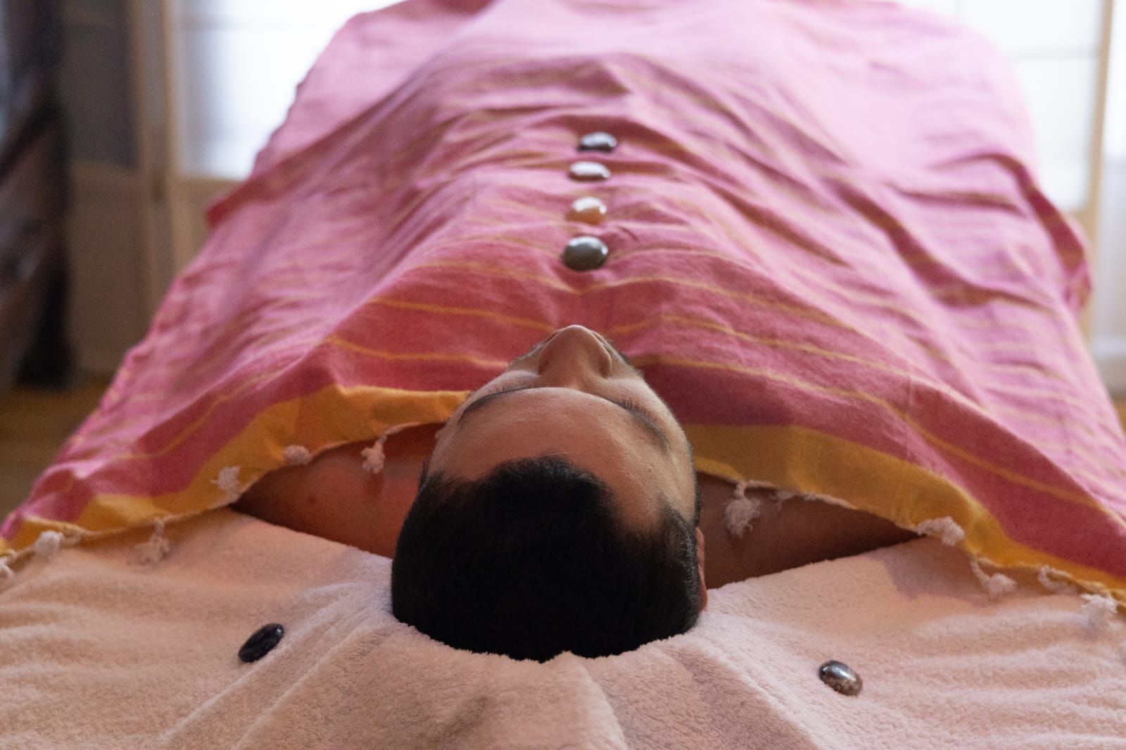 Pierres de basalte chauffées alignées le long du dos pour un massage signature